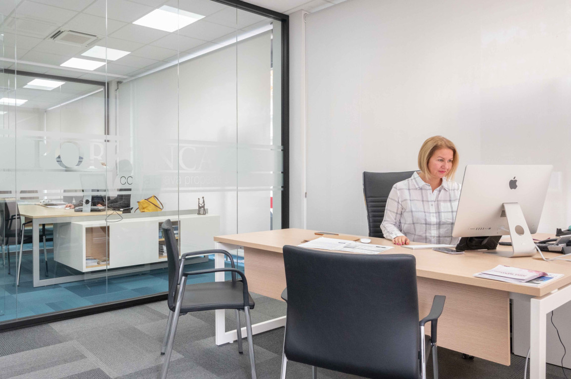 Interior of offices of Porfinca with secretary working behind computer.